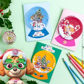 Drei bunte PAW Patrol Weihnachtskarten vor einem festlich geschmückten Hintergrund zum Nachbasteln