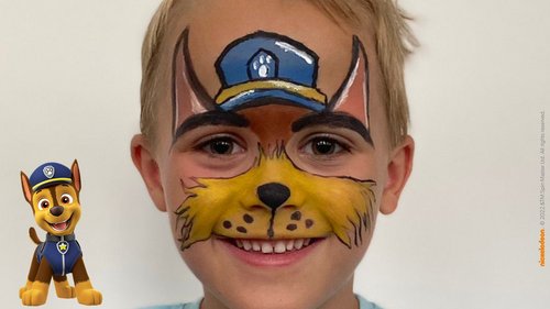 Ein glückliches Kind, das wie Chase von PAW Patrol geschminkt ist